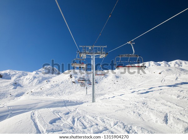 Chair lift in\
the mountains against the blue\
sky