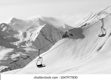 Chair lift at ski resort at winter day. Caucasus Mountains, Georgia, region Gudauri. Black and white toned landscape.