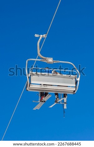 Chair lift with skiers at ski resort
