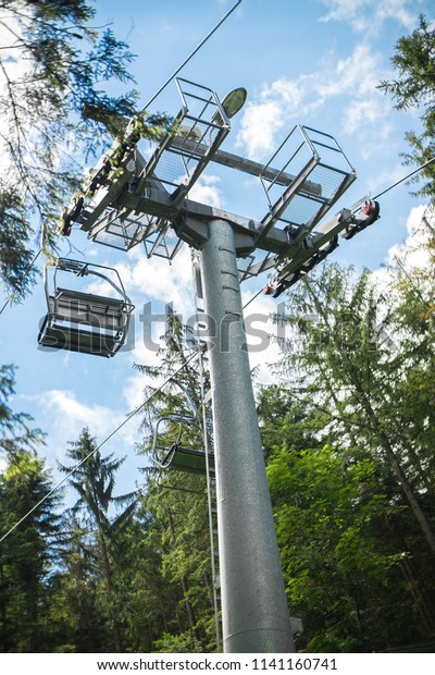 Chair lift in the\
woods in the mountains.