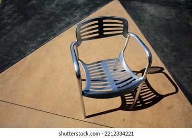 Chair. Patio Furniture. Aluminum Chair And Table On A Patio. Restaurant Chair. Outdoor Seating. Metal Furniture For Relaxing And Dining. Outside Cafe Chair And Table For Eating And Relaxing. 