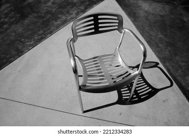 Chair. Patio Furniture. Aluminum Chair And Table On A Patio. Restaurant Chair. Outdoor Seating. Metal Furniture For Relaxing And Dining. Outside Cafe Chair And Table For Eating And Relaxing. 