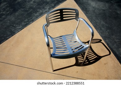 Chair. Patio Furniture. Aluminum Chair And Table On A Patio. Restaurant Chair. Outdoor Seating. Metal Furniture For Relaxing And Dining. Outside Cafe Chair And Table For Eating And Relaxing. 