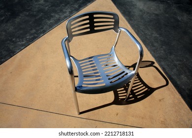 Chair. Patio Furniture. Aluminum Chair And Table On A Patio. Restaurant Chair. Outdoor Seating. Metal Furniture For Relaxing And Dining. Outside Cafe Chair And Table For Eating And Relaxing. 