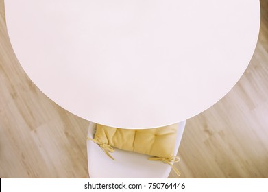 Chair With Pillow And Round Table With White Copy Space, Top View Over Wood Floor.