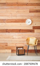 Chair And Rack With Magazines Near Wooden Wall In Room