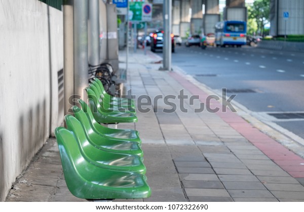 chair for sitting for waiting for the bus is located\
at the bus stop