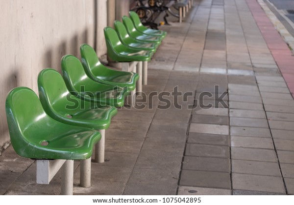 chair for sitting for waiting for the bus is located\
at the bus stop
