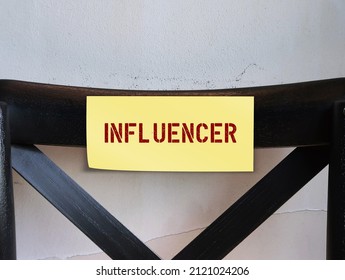 Chair with stick note label INFLUENCER, refer to one who has power to affect purchase decisions of others because of their authority, knowledge, position or relationship