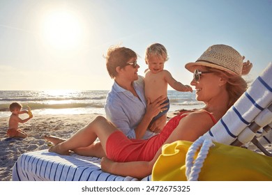 Chair, sunset or family with woman at beach on holiday vacation or weekend together with dad or kids. Father, calm mother or children siblings at sea for bonding or break in nature in Spain in summer - Powered by Shutterstock