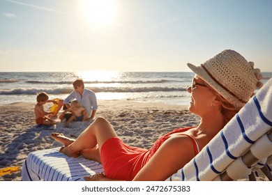 Chair, sunset or kids with woman at beach on holiday vacation or weekend together with dad or family. Father, calm mother or children siblings at sea for bonding or break in nature in Spain in summer - Powered by Shutterstock