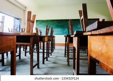 chair and table in class room with black board background, no student, school closed concept - Shutterstock ID 1334329124