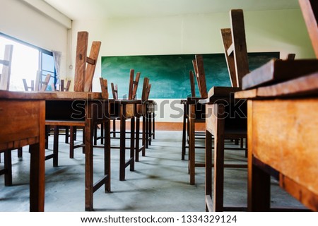 chair and table in class room with black board background, no student, school closed concept