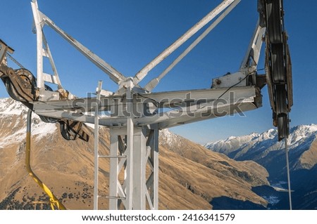 Chairlift at the ski resort. Ascent by cable car to the top of the mountain. Steel cable, blocks and rollers of a suspended cable car. Holidays in the highlands in winter. Supports of the cable car.
