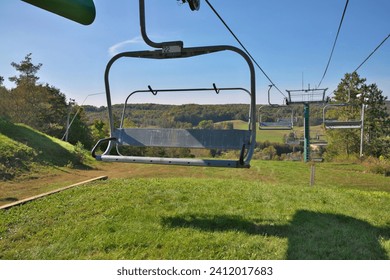 Chairlifts at ski resort in fall with no snow and lots of grass