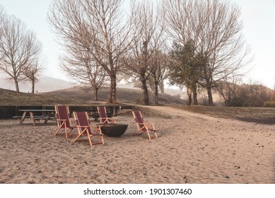 Chairs Around A Fire Pit On A Lakeside Beach