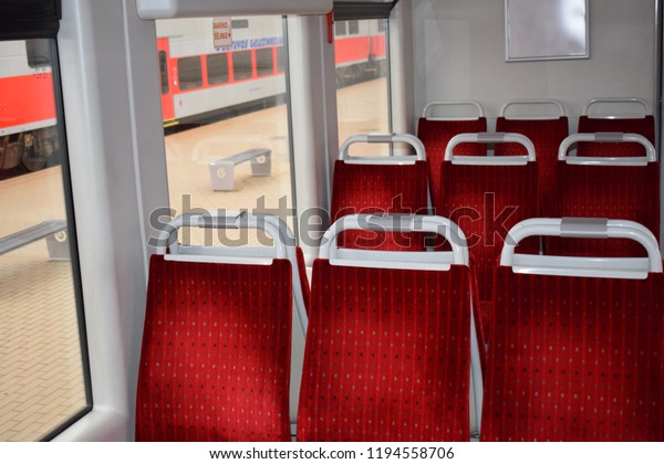 Chairs in an electric train with red velor\
upholstery. The interior of the train\
car.
