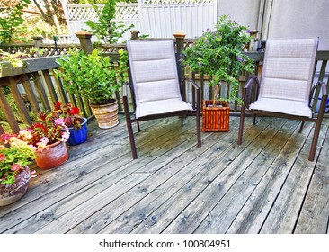 Chairs And Plants On Wooden Deck In Backyard Of Home