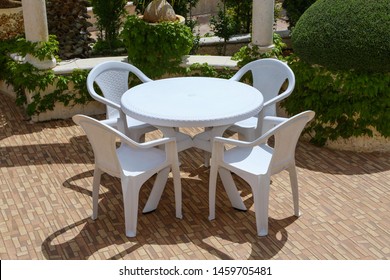 Chairs With A Plastic Table In A Garden 