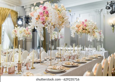 Chairs with round backs stand at dinner table with orchids