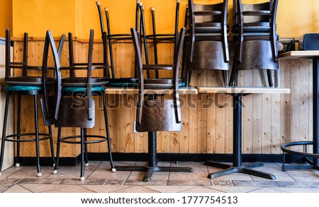 Chairs and Stools Stacked on Tables in an Empty Closed Restaurant during Covid-19 Pandemic