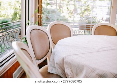 Chairs surround a table covered with a plaid tablecloth.