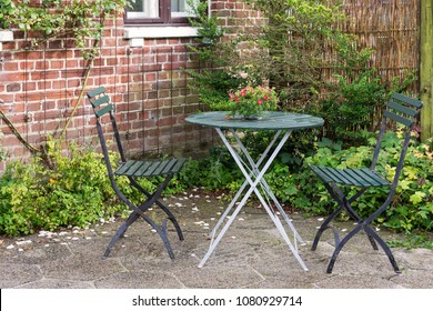 Chairs And Table In The Garden Of An Idyllic Rural Cottage House, Denmark.