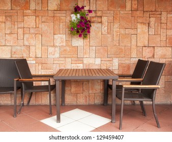 Chairs and table standing at the brick wall