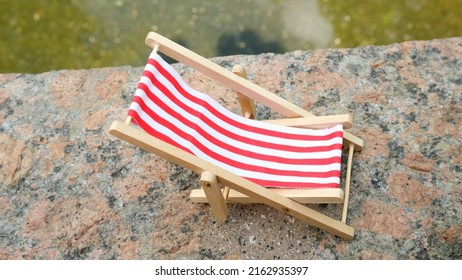 Chaise Lounge Chair With Red Stripes For Relaxing.