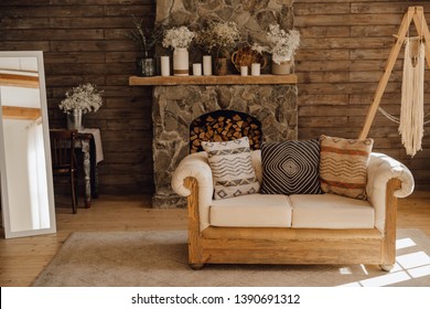 Chalet Cozy Interior Wooden Sofa and Fireplace. Rustic Home Design for Warm Indoor Space Alpine Vacation. Modern Cottage Living Room Decor with Wood Wall and Furniture. Winter Holiday Background