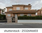 Chalet, view from the street, in a residential area in Sagunto, Spain, at dusk. Buildings of contemporary architecture, early 21st century