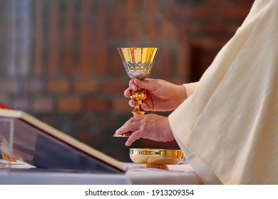 Chalice In The Hands Of The Priest On The Altar During The Celebration Of The Mass And Empty Space For Text