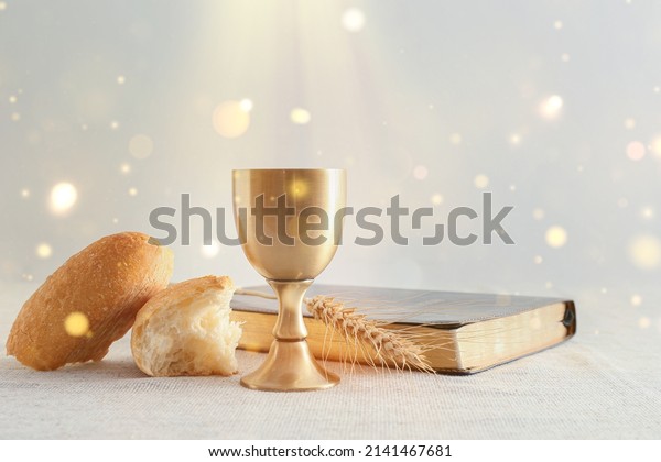 Chalice of wine with bread and Bible on light\
background. Holy Communion\
concept