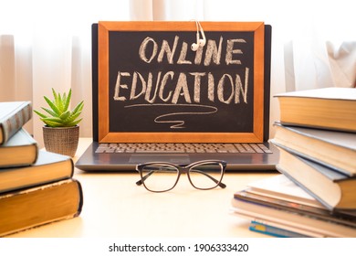 Chalk board - online learning, computer and a stack of books. Remote education concept.