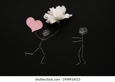 Chalk drawing man is holding red heart   flower   running to boy  Blackboard chalkboard background  Valentines day  love  relationship  attraction concept  Flat lay
