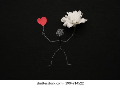 Chalk drawing man is holding red heart   flower  Blackboard chalkboard background  Valentines day  love  relationship  attraction concept  Flat lay