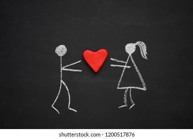 Chalk drawing man   woman holding together volumetric red heart  Blackboard chalkboard background  Love  relationship  attraction concept  Flat lay     