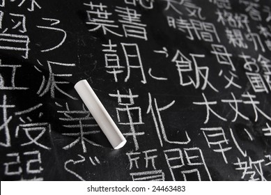 Chalk on blackboard filled with Chinese and Japanese characters. The words in Japanese have random meanings.