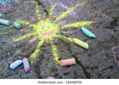 Chalk painting of a happy sun on the pavement