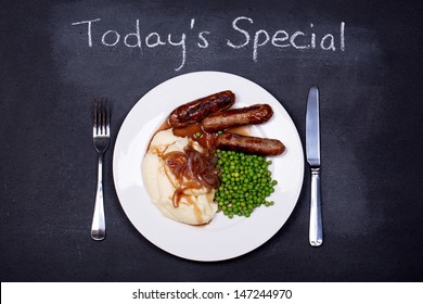 Chalkboard Advertising The Daily Special Of Sausages And Mash