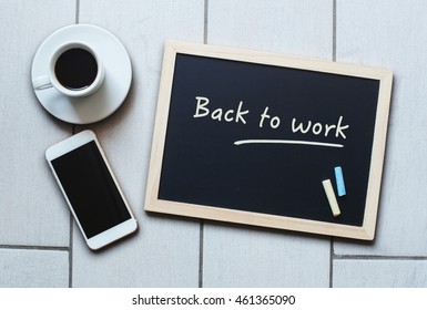 Chalkboard or Blackboard concept saying Back to Work with coffee and mobile phone. The concept education, training, after vacation, maternity leave, break.