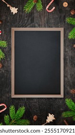 Chalkboard centered on a table surrounded by Christmas tree branches and decorations, featuring an empty surface for writing promotional text in a festive setting