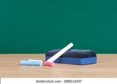 A Chalkboard With Chalk And Chalk Eraser On Desk