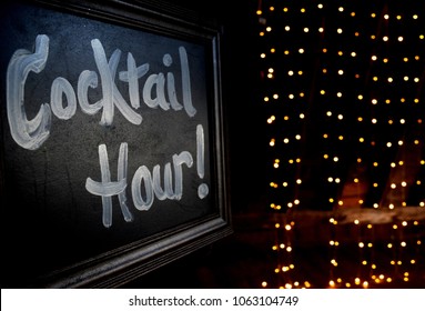 Chalkboard Cocktail Hour Sign With Lights In Background