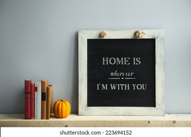 Chalkboard Frame On The Grey Wall With Books And Pumpkin HOME IS WHEREVER I'AM WITH YOU