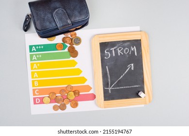 Chalkboard with the german word for electricity, Euro money coins, power consumption grafic, increasing energy costs, green technology, inflation, poverty and environmetal issue