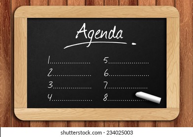 Chalkboard On The Wooden Table Written Agenda.