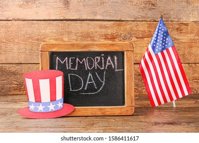 Chalkboard, paper hat and USA flag on wooden background. Memorial Day celebration - Shutterstock ID 1586411617