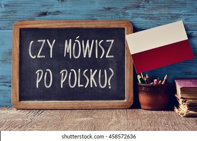 a chalkboard with the question czy mowisz po polsku?, do you speak Polish? written in Polish, a pot with pencils, some books and the flag of Poland