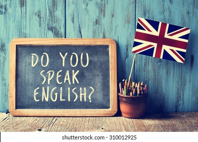 a chalkboard with the text do you speak english? written in it, a pot with pencils and the flag of the United Kingdom, on a wooden desk, with a filter effect